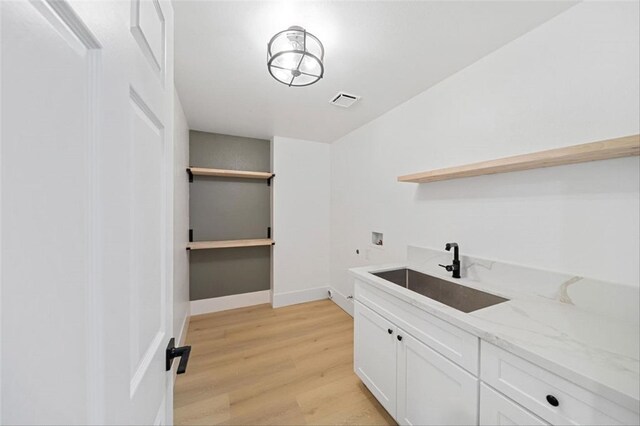 30901 Wellington Cir, Temecula, CA 92591 - laundry area with hookup for a washing machine, cabinet space, light wood-style floors, and baseboards