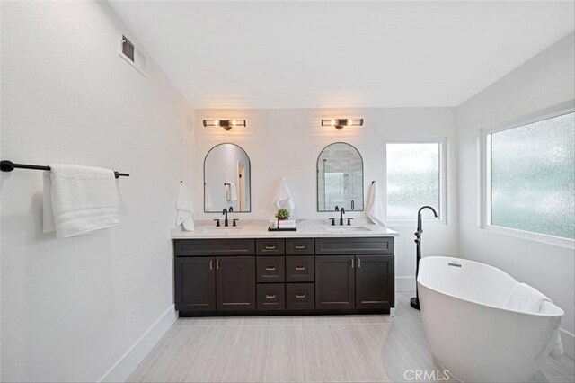 30901 Wellington Cir, Temecula, CA 92591 - bathroom featuring double vanity, a soaking tub, and baseboards