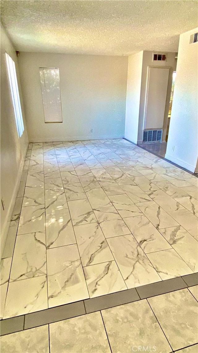 2260 Q4 Ave E Unit 70, Palmdale, CA 93550 - empty room with light marble finish floors, a textured ceiling, and baseboards