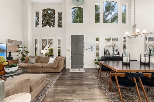 2130 Almeria St Unit 101, Corona, CA 92879 - living room with a chandelier, a towering ceiling, plenty of natural light, dark wood-style floors, and baseboards