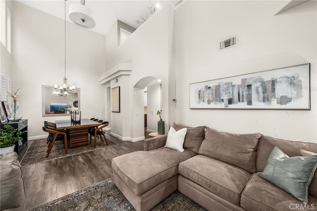 2130 Almeria St Unit 101, Corona, CA 92879 - living area featuring arched walkways, a high ceiling, a chandelier, baseboards, and dark wood finished floors