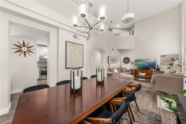 2130 Almeria St Unit 101, Corona, CA 92879 - dining room with arched walkways, a chandelier, wood finished floors, baseboards, and a high ceiling