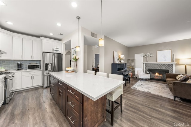 2130 Almeria St Unit 101, Corona, CA 92879 - kitchen with stainless steel appliances, a kitchen breakfast bar, open floor plan, dark wood-style flooring, and white cabinets