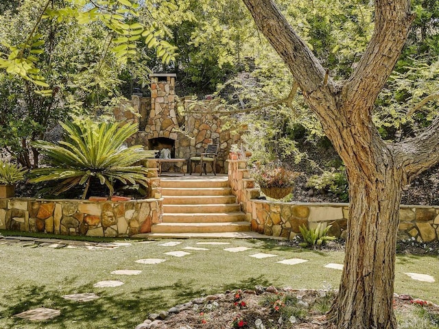 view of yard featuring an outdoor stone fireplace