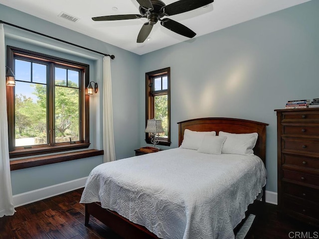 bedroom featuring baseboards, wood finished floors, and a ceiling fan