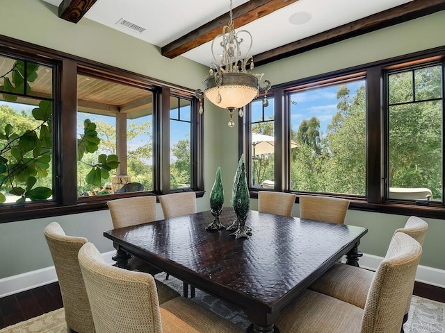 dining room featuring baseboards, wood finished floors, beamed ceiling, and a chandelier