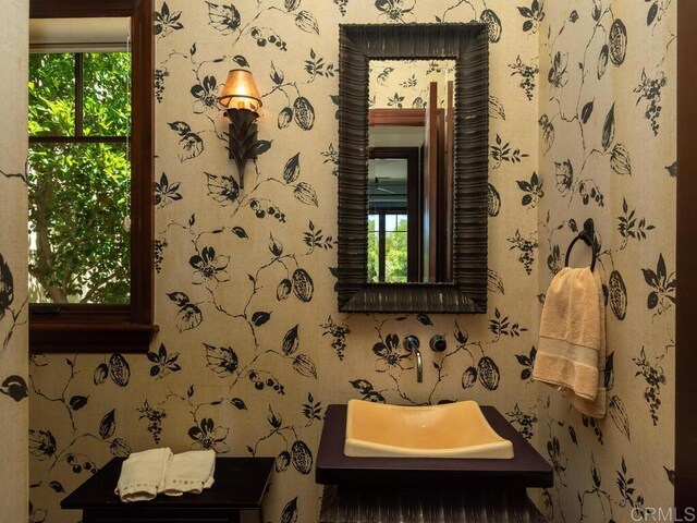 bathroom with wallpapered walls