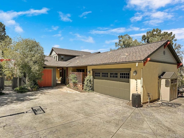 view of front of house featuring an attached garage, fence, concrete driveway, and stucco siding