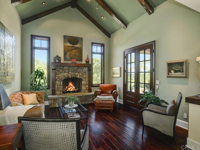 sitting room featuring baseboards, hardwood / wood-style flooring, and a stone fireplace