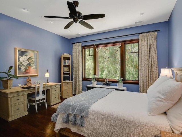 bedroom featuring dark wood-style floors, a ceiling fan, and an office area