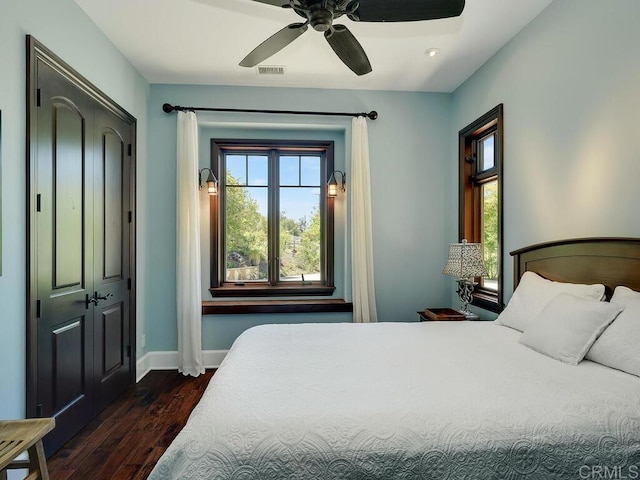 bedroom featuring dark wood-style floors, baseboards, and a ceiling fan