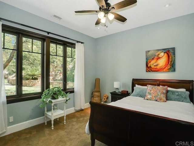 carpeted bedroom featuring baseboards and a ceiling fan