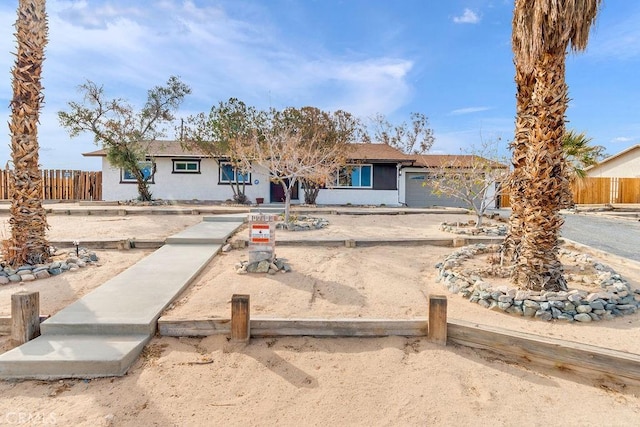 ranch-style home with fence and stucco siding