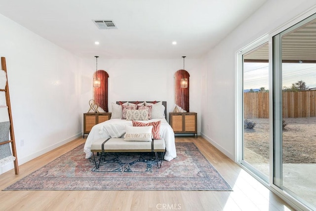 bedroom featuring light wood-style flooring, access to outside, arched walkways, baseboards, and recessed lighting