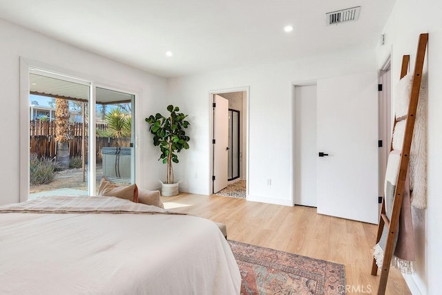 bedroom with access to exterior, light wood-type flooring, recessed lighting, and ensuite bath