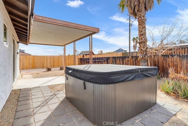 view of patio with a hot tub and a fenced backyard