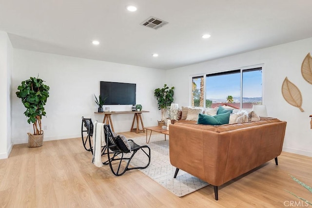 living area featuring light wood-style floors, recessed lighting, and baseboards