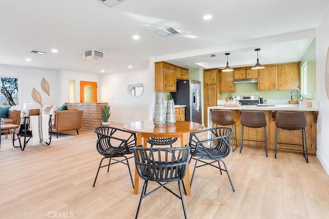 dining space with light wood-style floors and recessed lighting
