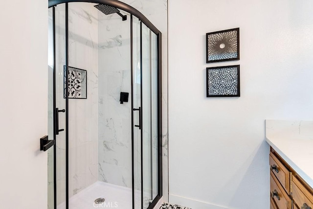 full bath with a marble finish shower and vanity