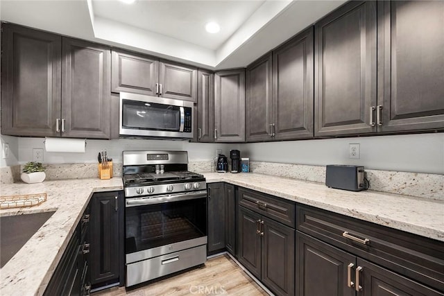 5814 Old Village Rd Unit 216, Yorba Linda, CA 92887 - kitchen featuring appliances with stainless steel finishes, light stone counters, light wood-style flooring, recessed lighting, and a tray ceiling