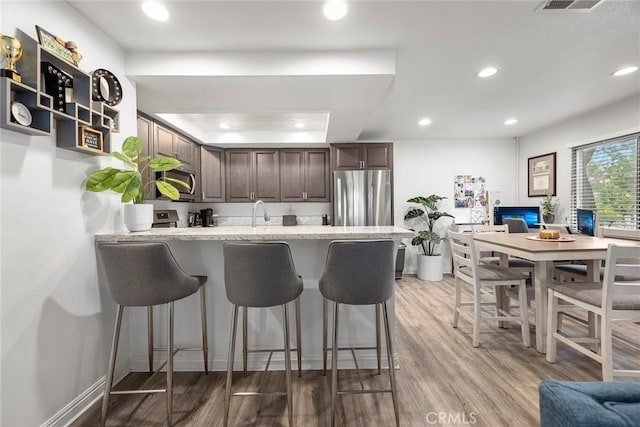 5814 Old Village Rd Unit 216, Yorba Linda, CA 92887 - kitchen featuring freestanding refrigerator, a peninsula, a kitchen bar, recessed lighting, and light wood-style flooring