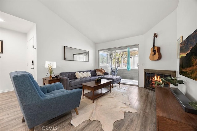 5814 Old Village Rd Unit 216, Yorba Linda, CA 92887 - living area with vaulted ceiling, light wood-type flooring, a glass covered fireplace, and baseboards