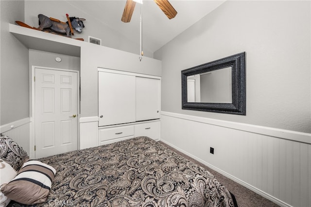 35189 Ravencrest Ct, Yucaipa, CA 92399 - bedroom featuring a wainscoted wall, vaulted ceiling, carpet, a closet, and ceiling fan