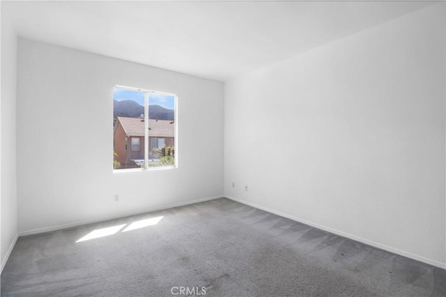 empty room featuring carpet and baseboards
