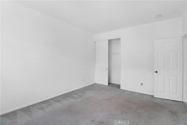 unfurnished bedroom featuring carpet and a closet