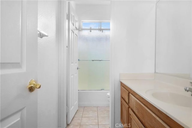 bathroom featuring vanity, shower / bath combination with glass door, tile patterned floors, and toilet
