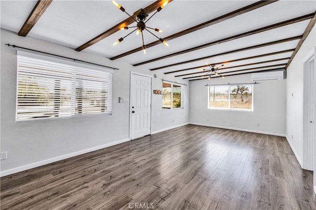 57330 Old Haggard Rd, Yucca Valley, CA 92284 - unfurnished living room featuring a chandelier, a wall unit AC, beam ceiling, dark wood-type flooring, and baseboards