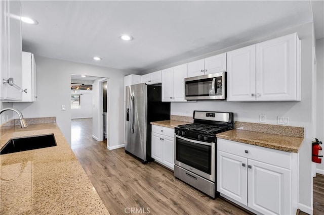 57330 Old Haggard Rd, Yucca Valley, CA 92284 - kitchen with stainless steel appliances, a sink, wood finished floors, white cabinetry, and recessed lighting