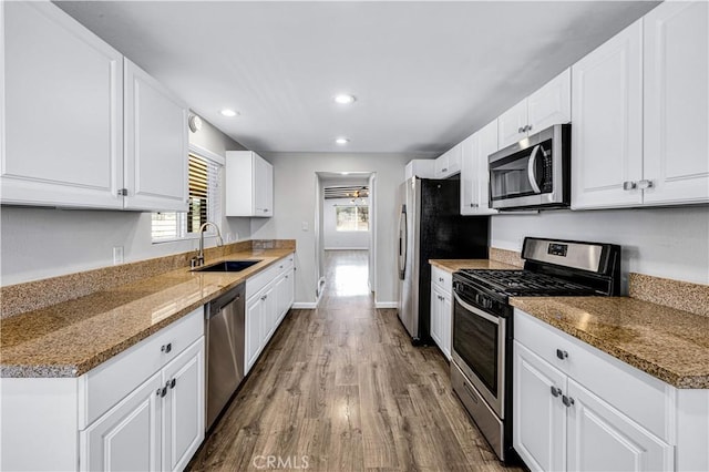 57330 Old Haggard Rd, Yucca Valley, CA 92284 - kitchen featuring stainless steel appliances, a sink, wood finished floors, white cabinetry, and light stone countertops