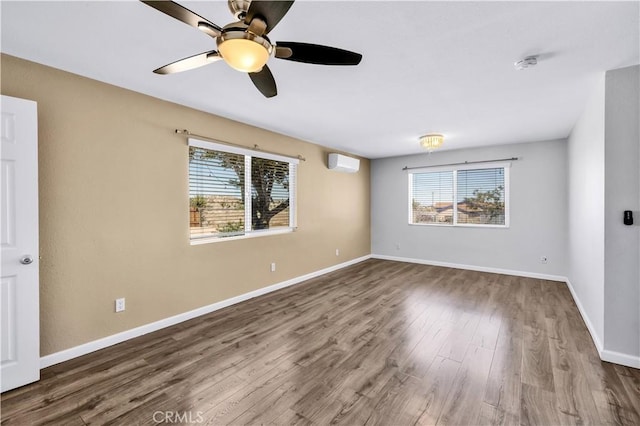 57330 Old Haggard Rd, Yucca Valley, CA 92284 - unfurnished room featuring a wall unit AC, plenty of natural light, wood finished floors, and a smoke detector