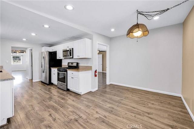 57330 Old Haggard Rd, Yucca Valley, CA 92284 - kitchen featuring stainless steel appliances, baseboards, light wood-style flooring, white cabinets, and recessed lighting
