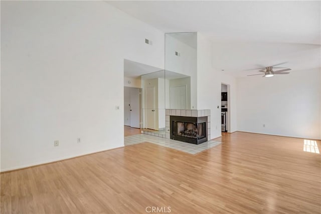 600 Central Ave Unit 372, Riverside, CA 92507 - unfurnished living room featuring light wood-type flooring, a ceiling fan, a tiled fireplace, and high vaulted ceiling