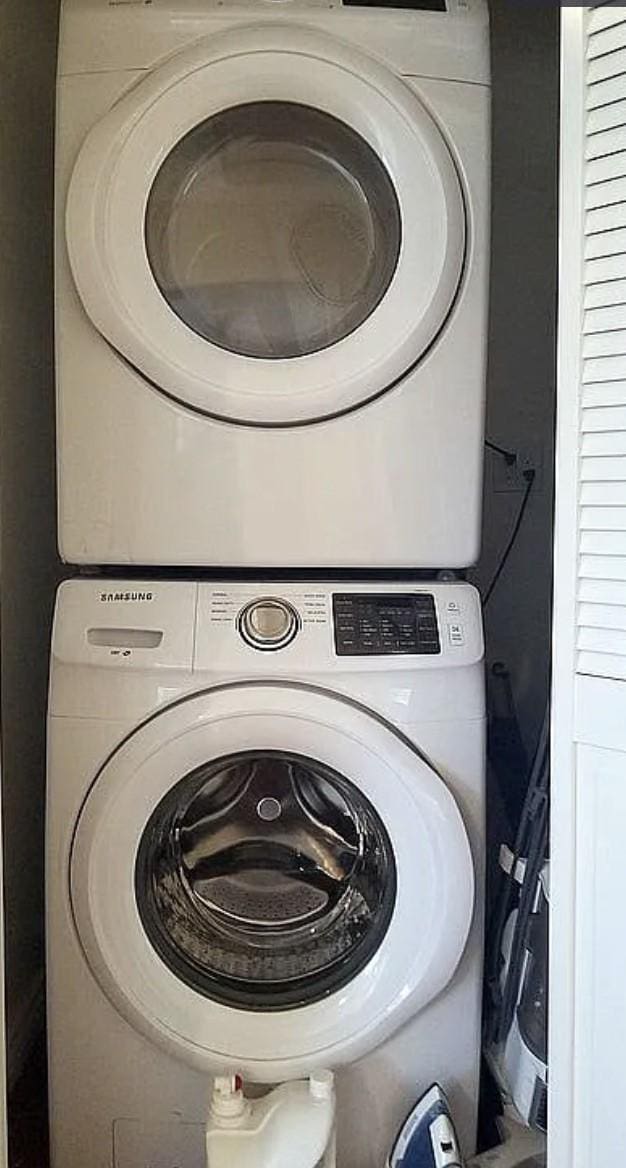 washroom featuring stacked washing machine and dryer