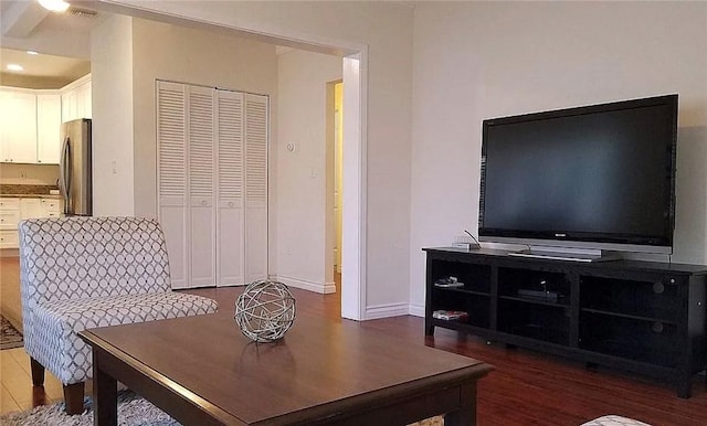 living area with dark wood-style flooring and baseboards