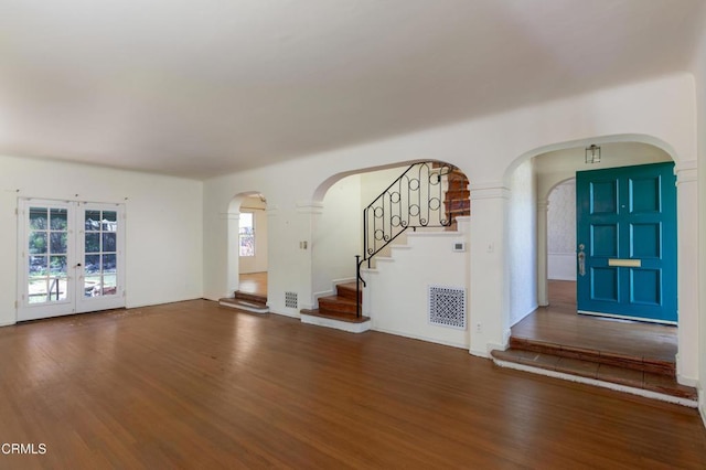 2577 Boulder Rd, Altadena, CA 91001 - unfurnished living room featuring wood finished floors, arched walkways, and stairway