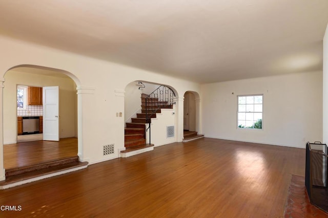 2577 Boulder Rd, Altadena, CA 91001 - unfurnished living room featuring arched walkways, wood finished floors, stairway, and baseboards
