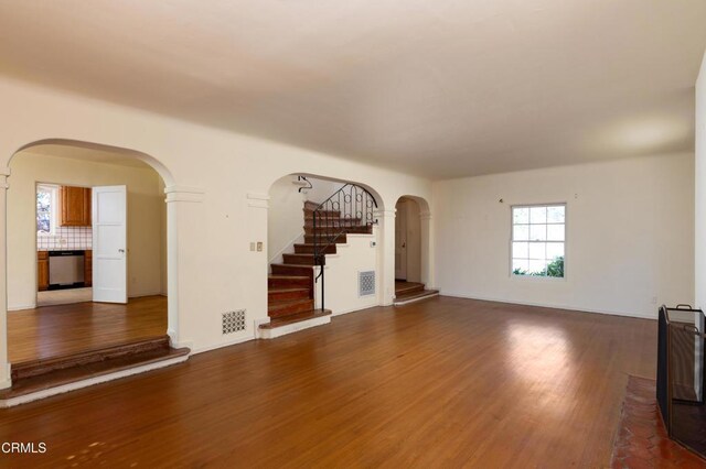 2577 Boulder Rd, Altadena, CA 91001 - unfurnished living room featuring arched walkways, wood finished floors, and stairway
