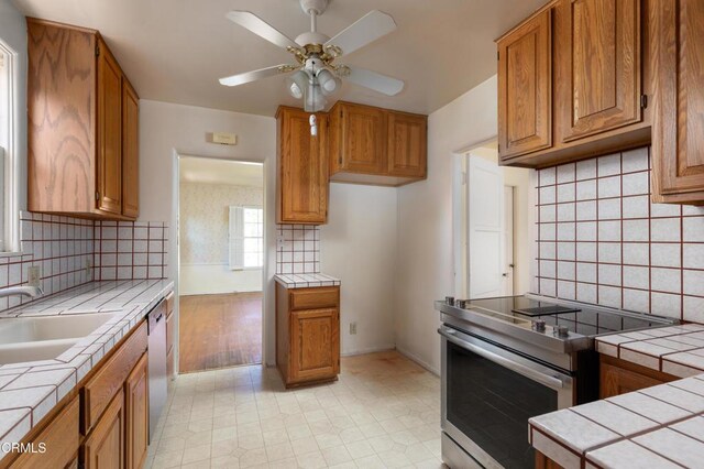 2577 Boulder Rd, Altadena, CA 91001 - kitchen with stainless steel appliances, tile counters, and brown cabinets