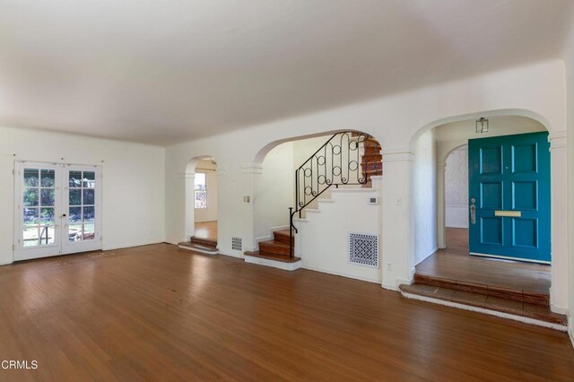 2577 Boulder Rd, Altadena, CA 91001 - unfurnished living room with wood finished floors, arched walkways, and stairs