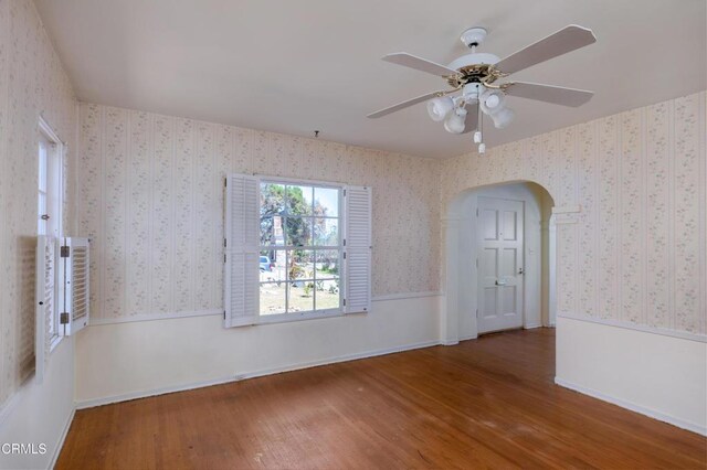 2577 Boulder Rd, Altadena, CA 91001 - empty room with wood finished floors, arched walkways, a ceiling fan, and wallpapered walls