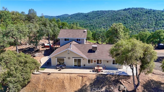 6097 Sherlock Rd, Midpines, CA 95345 - back of house featuring a view of trees, a patio, a mountain view, and stucco siding