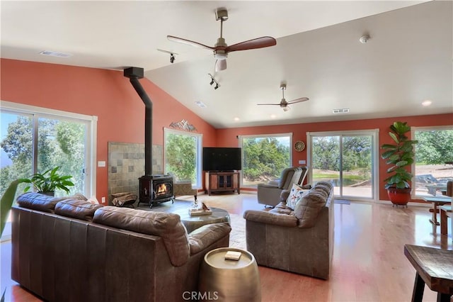 6097 Sherlock Rd, Midpines, CA 95345 - living area with a wood stove, vaulted ceiling, a ceiling fan, and light wood-style floors