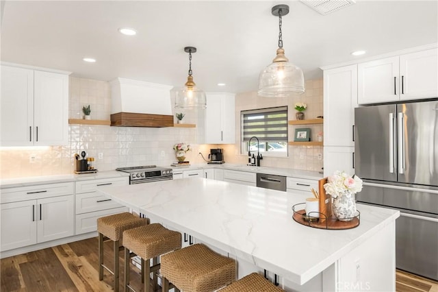 13381 Del Cerro Dr, Tustin, CA 92780 - kitchen featuring open shelves, appliances with stainless steel finishes, premium range hood, white cabinetry, and recessed lighting