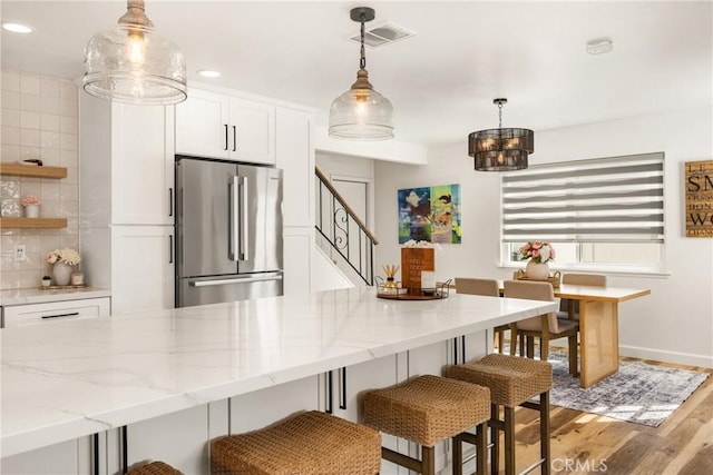 13381 Del Cerro Dr, Tustin, CA 92780 - kitchen featuring high end refrigerator, white cabinets, light wood-style floors, recessed lighting, and a chandelier