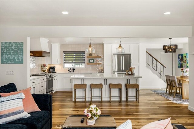 13381 Del Cerro Dr, Tustin, CA 92780 - living area with a chandelier, wood finished floors, stairway, and recessed lighting
