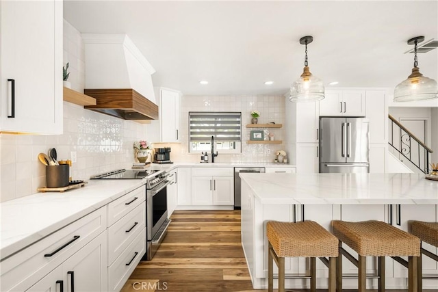 13381 Del Cerro Dr, Tustin, CA 92780 - kitchen with stainless steel appliances, open shelves, premium range hood, a kitchen breakfast bar, and a sink